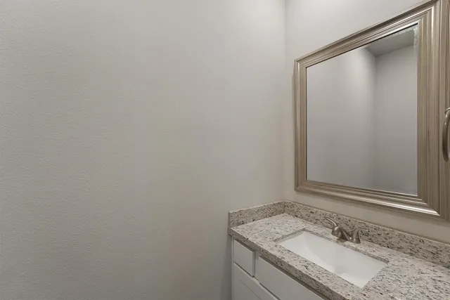 a bathroom with a granite countertop sink and vanity