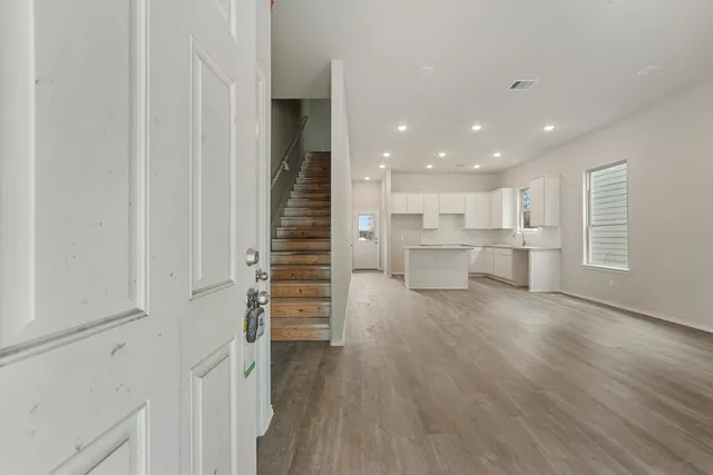 a view of a kitchen with wooden floor and windows