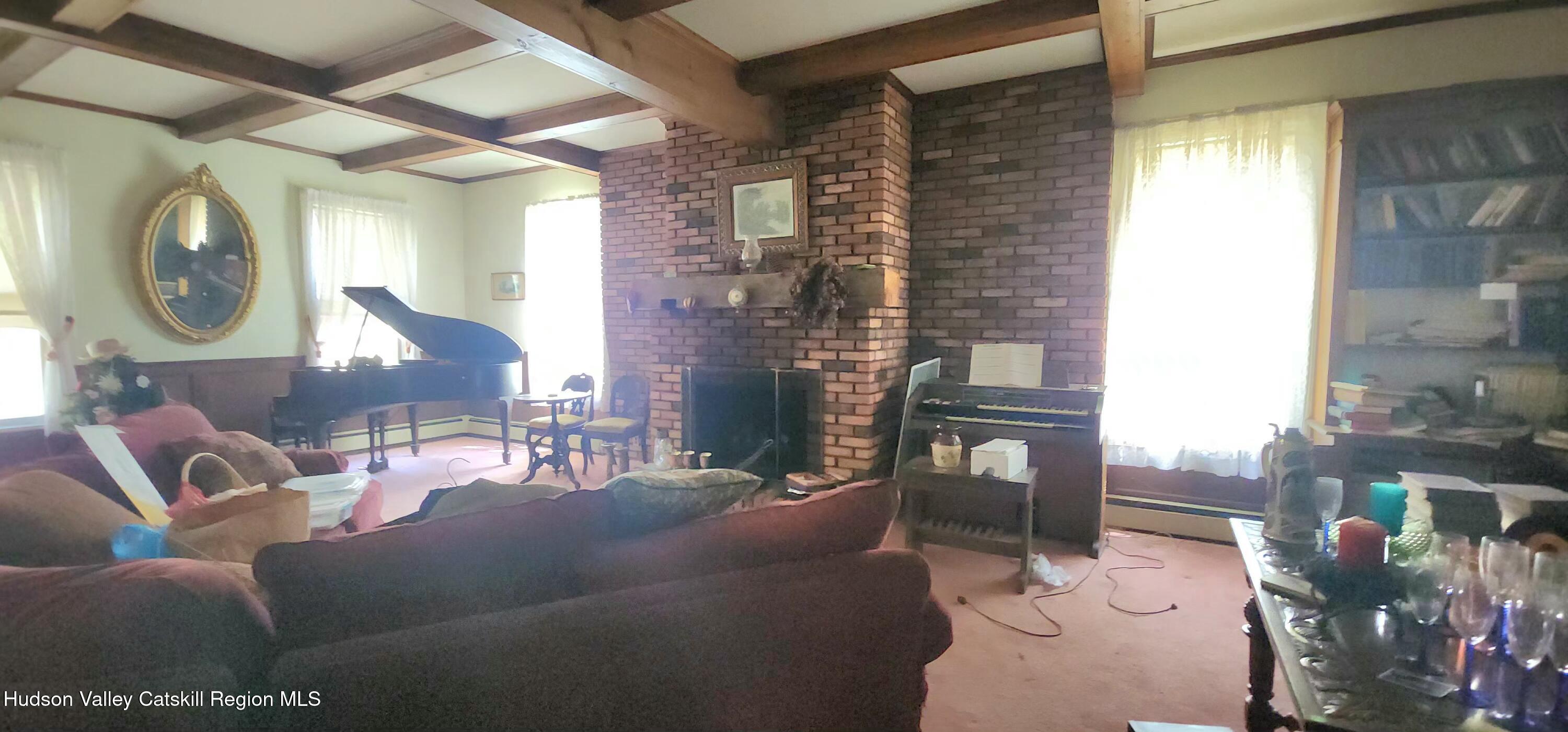 293 Carl Road Jewett, NY 12444 - Photo 11 of 20 a living room with furniture a chandelier and a fireplace