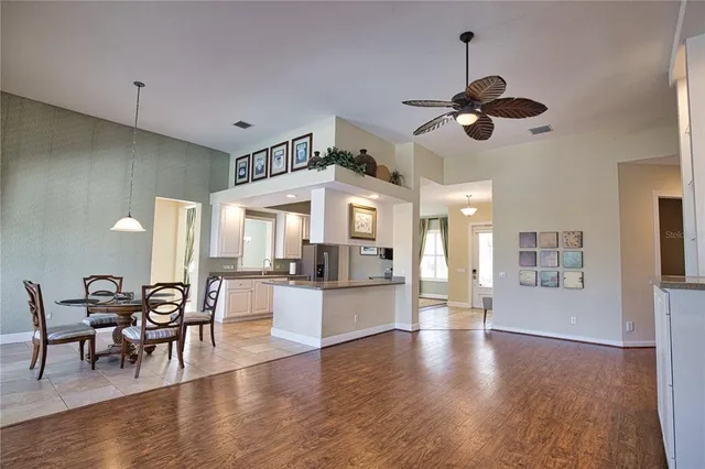 a view of a dining room and livingroom with furniture wooden floor a chandelier