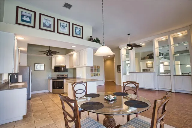 a kitchen with stainless steel appliances a dining table and chairs