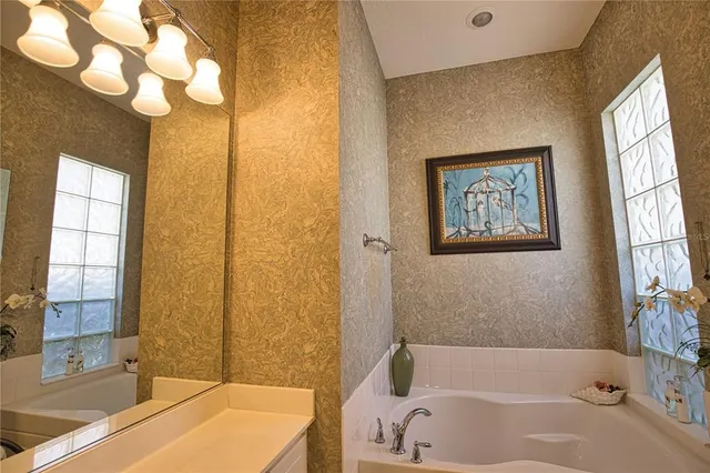 a bathroom with a tub a sink and a window