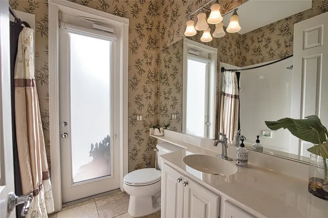 a bathroom with a granite countertop sink toilet and shower