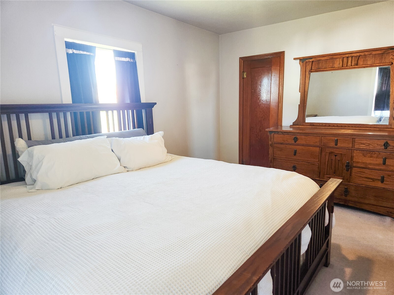 112 East 5th Street Lind, WA 99341 - Photo 16 of 39 a bedroom with a large bed and a flat tv screen on dresser