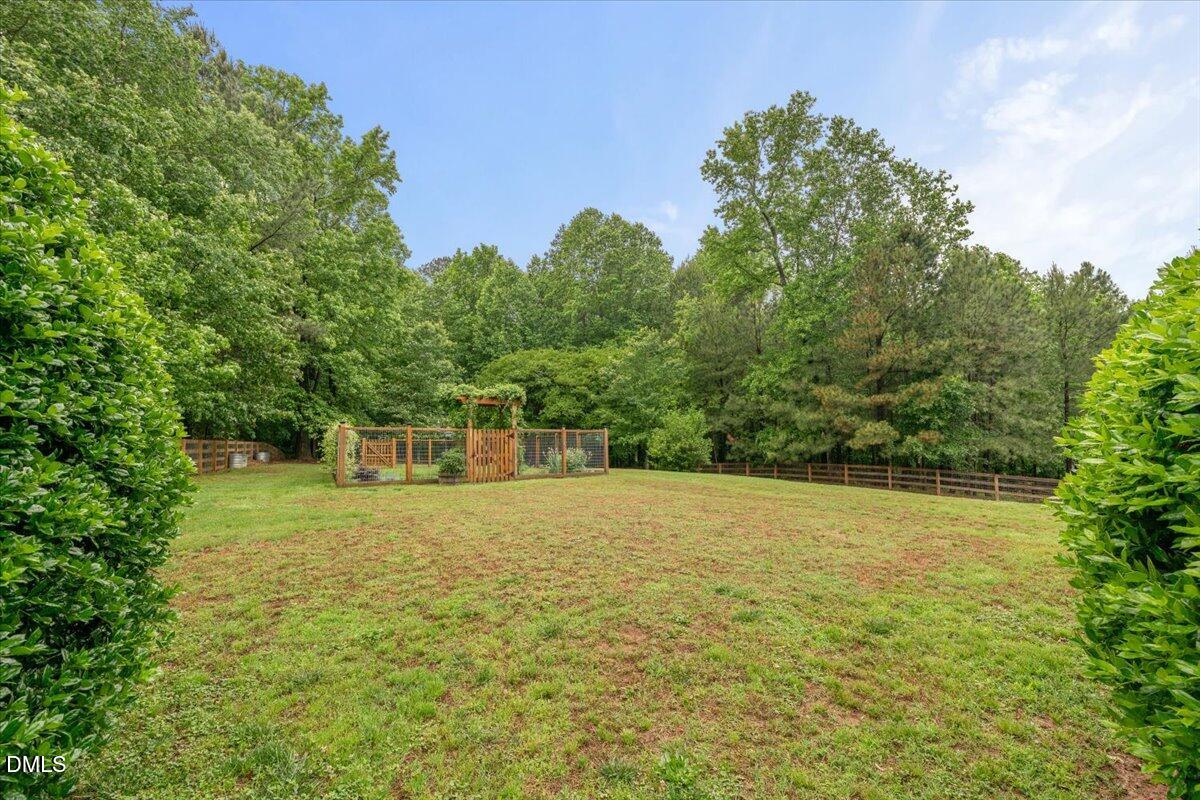 7400 Denlee Road Raleigh, NC 27603 - Photo 37 of 47 a view of a big yard with trees in the background