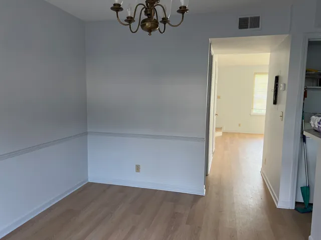 an empty room with wooden floor and a window