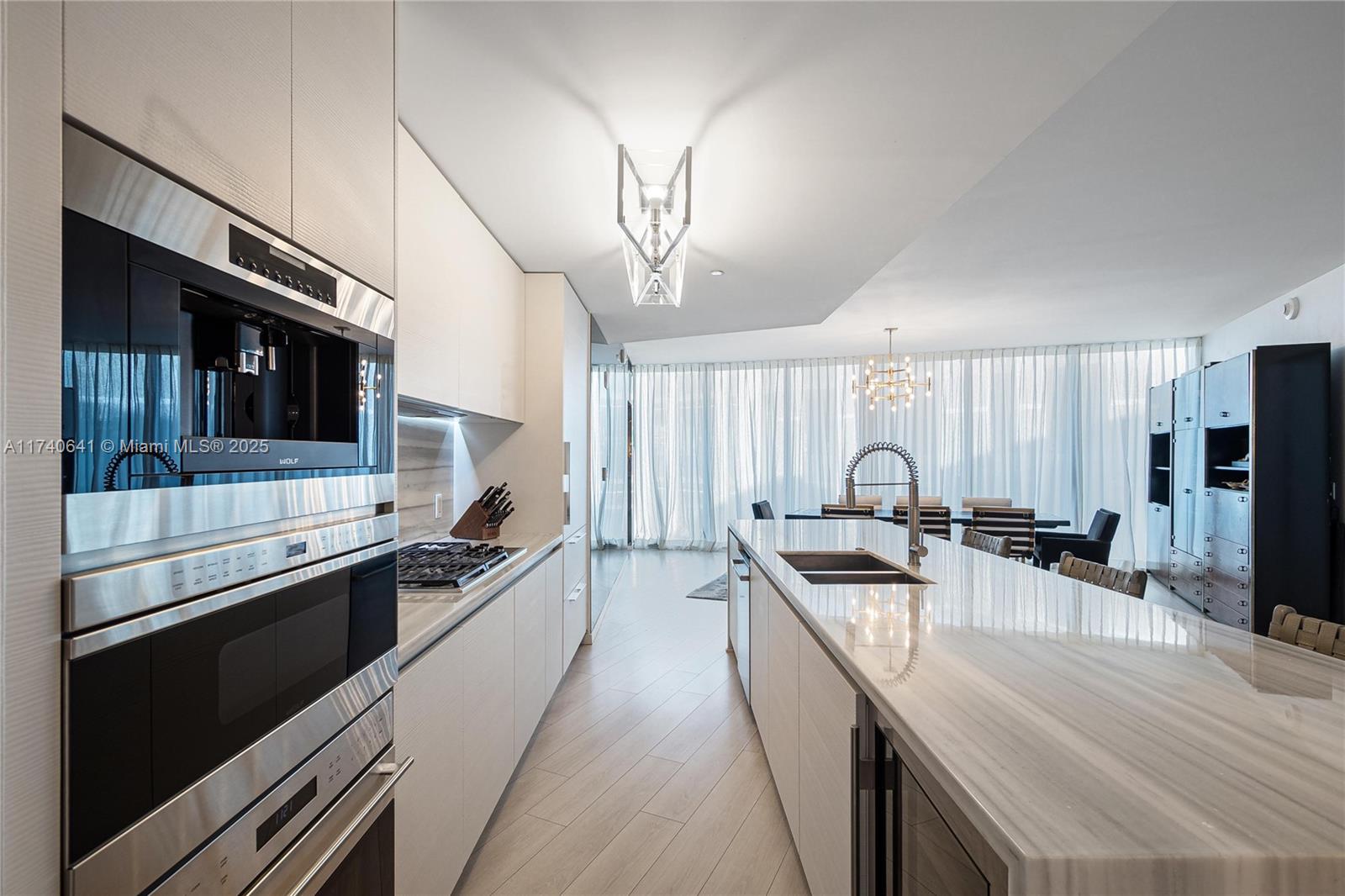 1 Collins Avenue, Unit 304 Miami Beach, FL 33139 - Photo 12 of 40 a kitchen with stainless steel appliances a stove sink microwave and cabinets