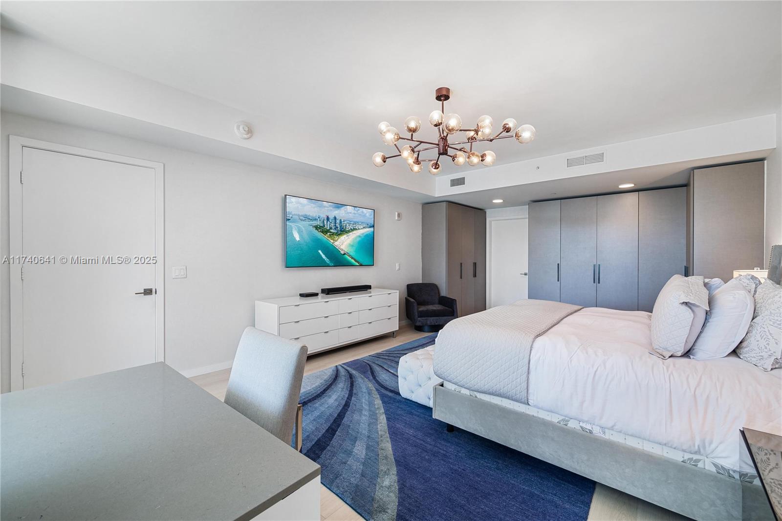 1 Collins Avenue, Unit 304 Miami Beach, FL 33139 - Photo 16 of 40 a bedroom with a bed and a flat screen tv