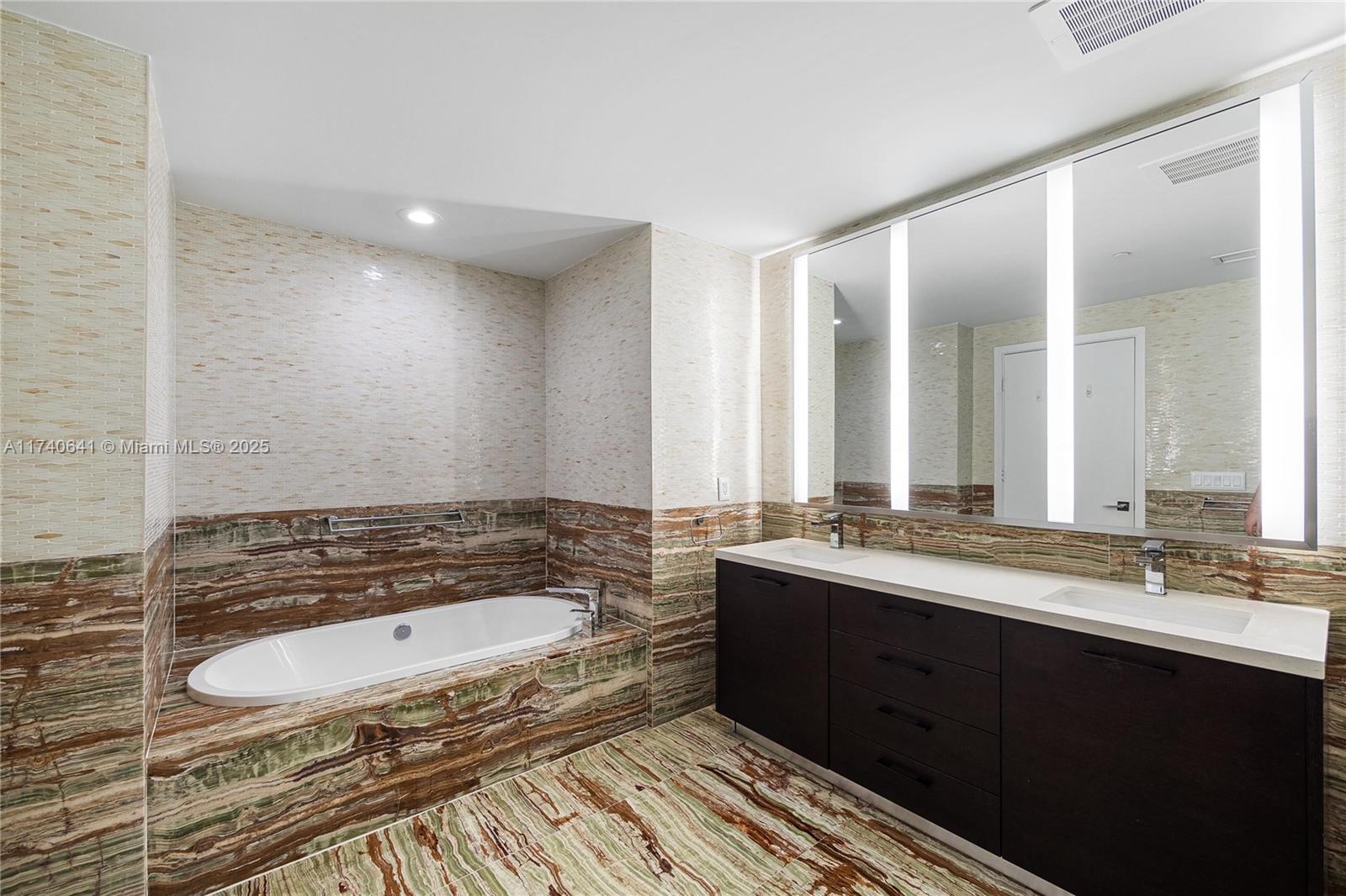 1 Collins Avenue, Unit 304 Miami Beach, FL 33139 - Photo 17 of 40 a bathroom with a sink and a mirror