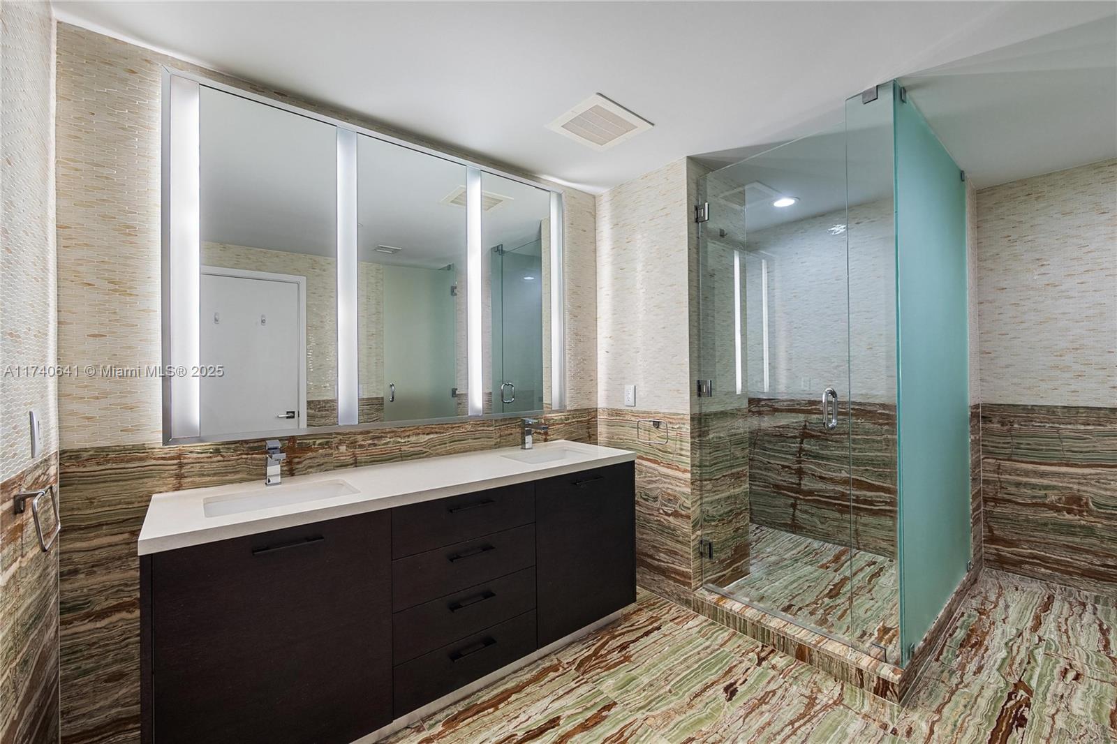 1 Collins Avenue, Unit 304 Miami Beach, FL 33139 - Photo 18 of 40 a bathroom with a double vanity sink and a mirror