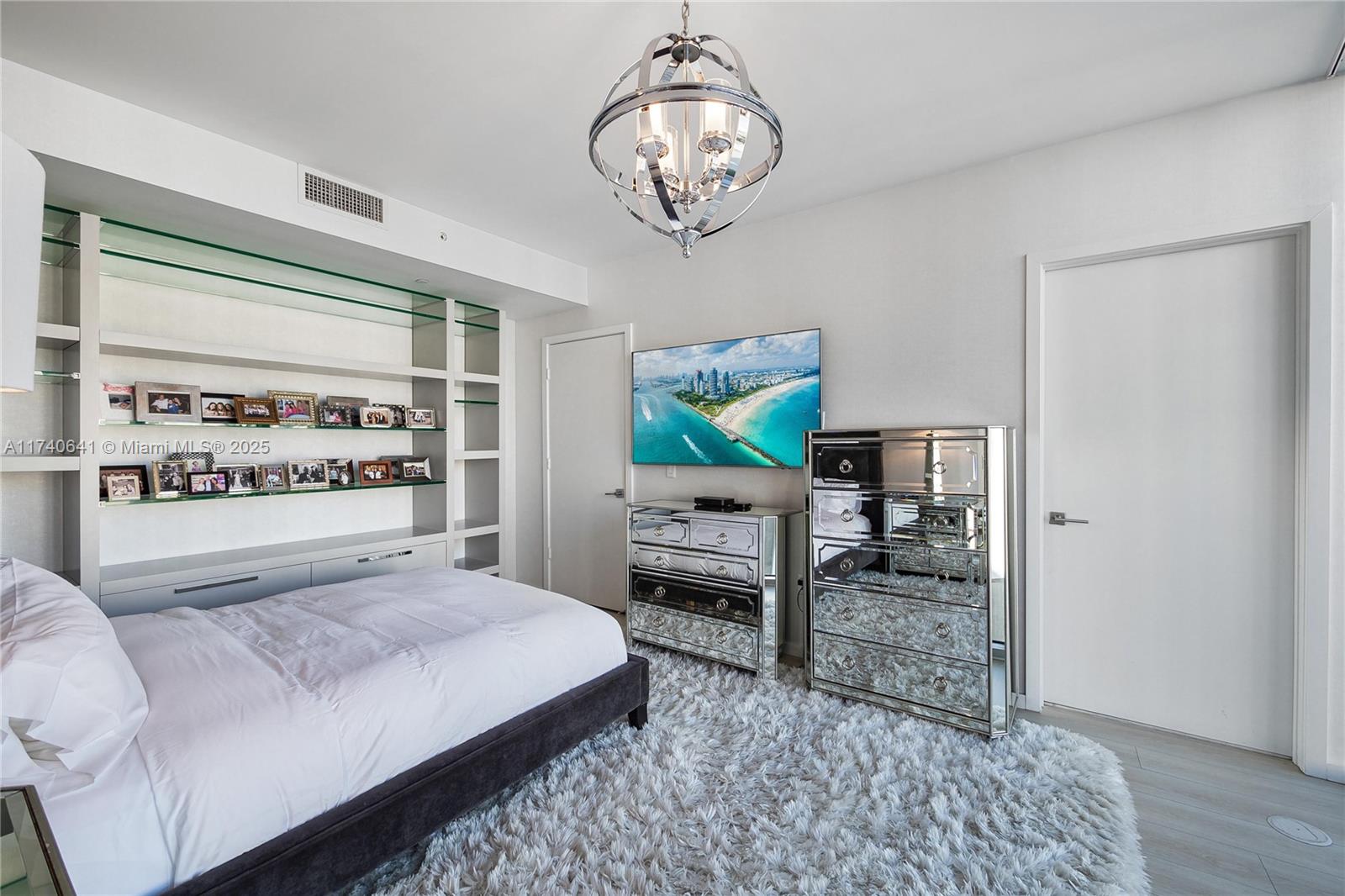 1 Collins Avenue, Unit 304 Miami Beach, FL 33139 - Photo 20 of 40 a bedroom with a bed a dresser and book shelf