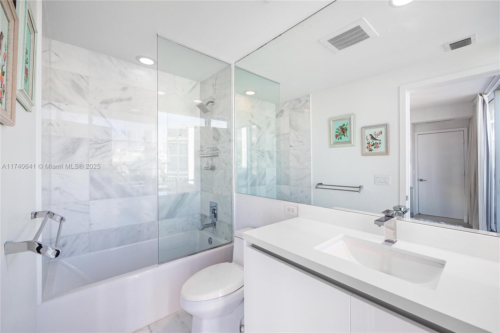 1 Collins Avenue, Unit 304 Miami Beach, FL 33139 - Photo 22 of 40 a bathroom with a sink a toilet and shower