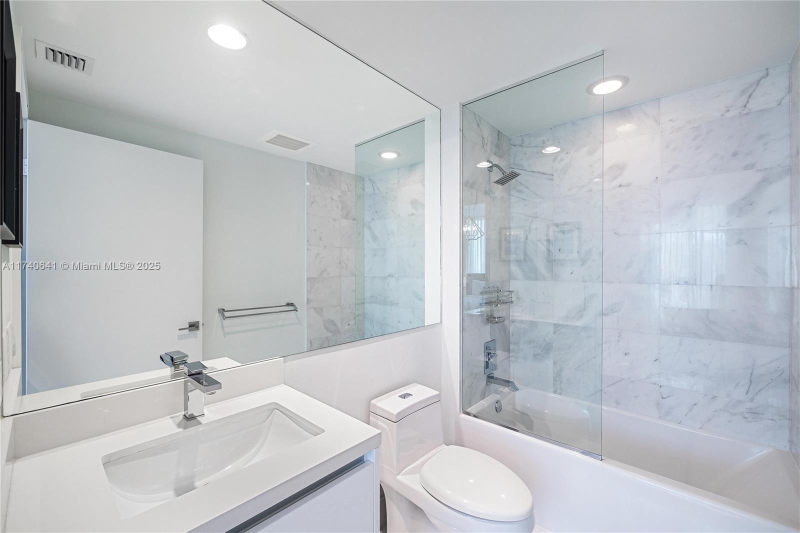 1 Collins Avenue, Unit 304 Miami Beach, FL 33139 - Photo 26 of 40 a bathroom with a sink a toilet and shower