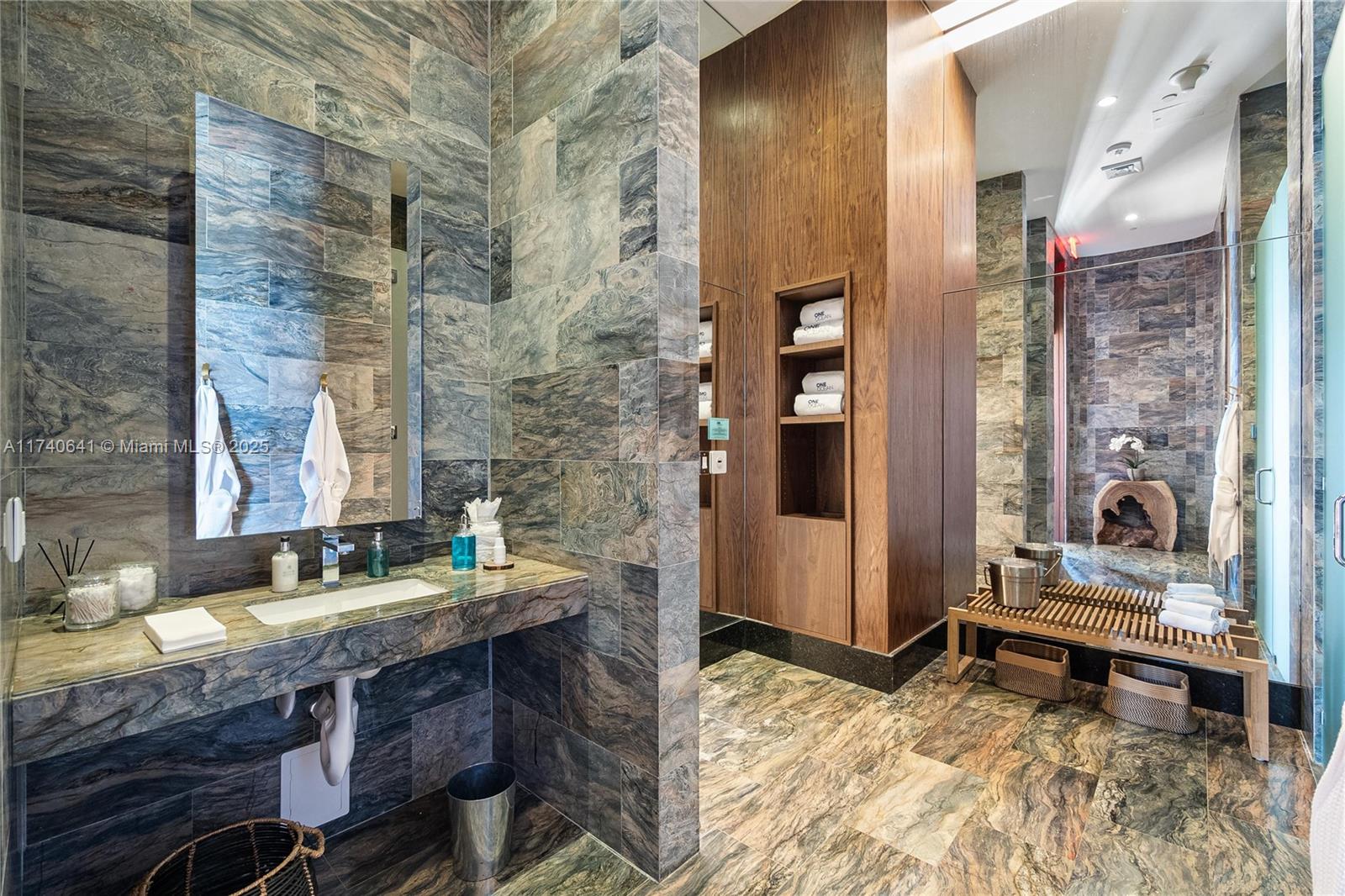 1 Collins Avenue, Unit 304 Miami Beach, FL 33139 - Photo 28 of 40 a bathroom with a granite countertop sink and a mirror