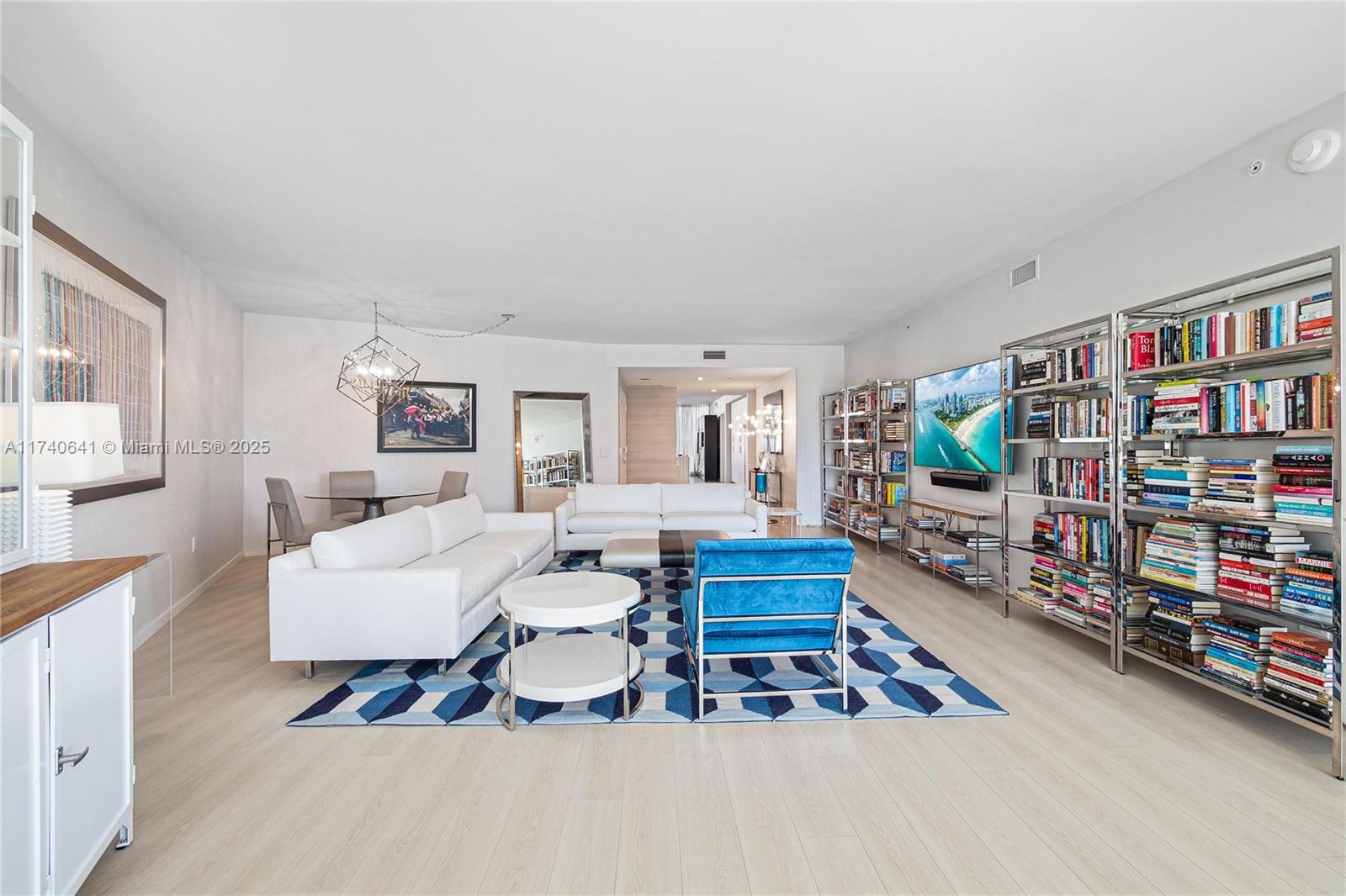1 Collins Avenue, Unit 304 Miami Beach, FL 33139 - Photo 5 of 40 a living room with furniture a rug and a book shelf