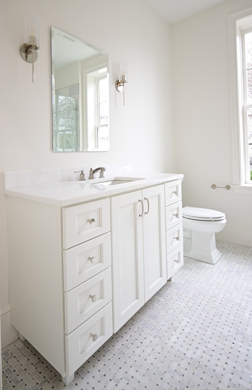 66 Pleasant Street, Unit 1 Marblehead, MA 01945 - Photo 16 of 19 a bathroom with a toilet sink and mirror