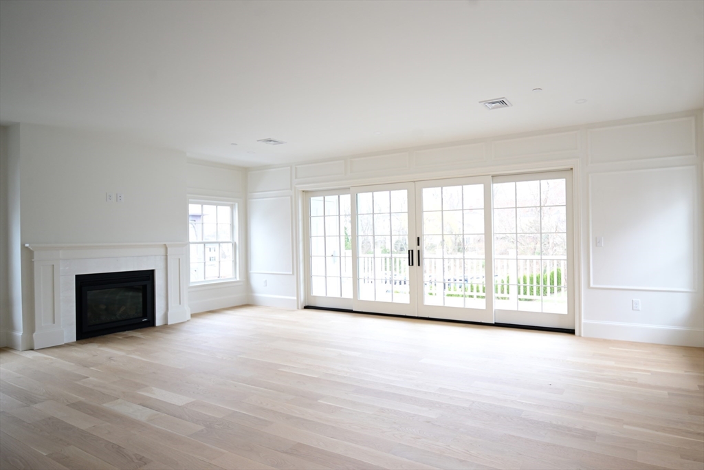 66 Pleasant Street, Unit 1 Marblehead, MA 01945 - Photo 5 of 19 a view of an empty room with a fireplace and a window
