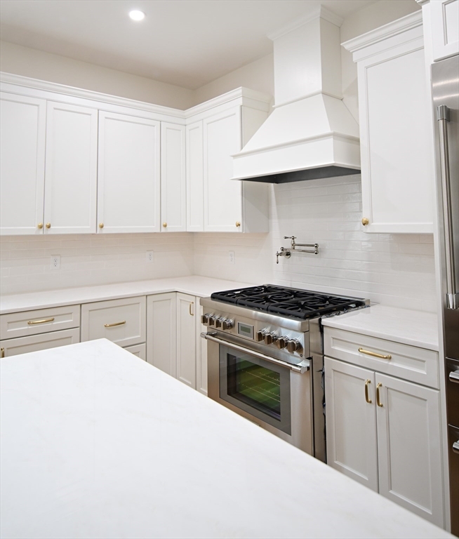 66 Pleasant Street, Unit 1 Marblehead, MA 01945 - Photo 9 of 19 a kitchen with white cabinets and appliances