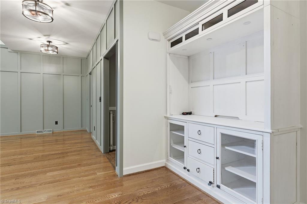 8861 Boylston Road Colfax, NC 27235 - Photo 9 of 50 Everyday living was thoughtfully considered, with a spacious hallway featuring custom millwork, built-in storage hooks, and convenient access between the kitchen, laundry, primary suite, and main living areas.