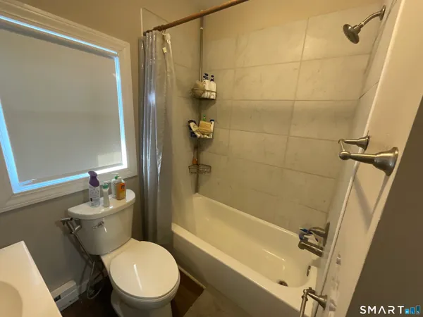 a white toilet sitting next to a bath tub shower
