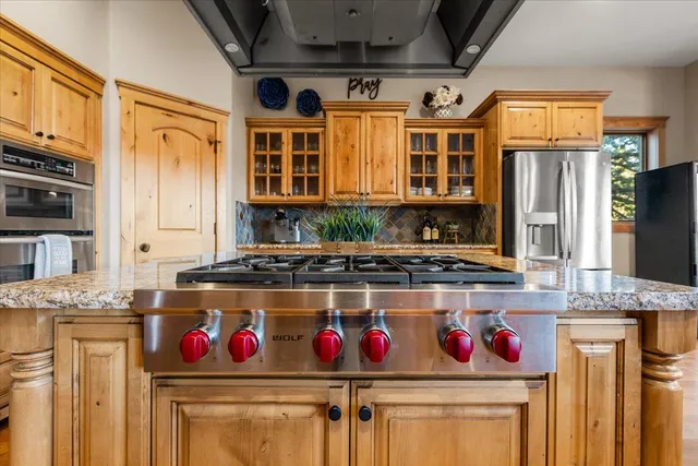 a kitchen with stainless steel appliances granite countertop a stove and a refrigerator