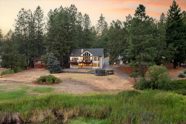 a pathway of a house with yard and lake view