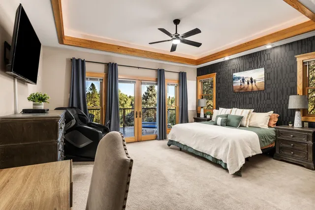 a bedroom with a bed a flat screen tv and a large window