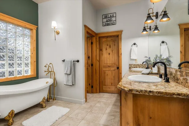a bathroom with a granite countertop sink mirror bathtub and toilet