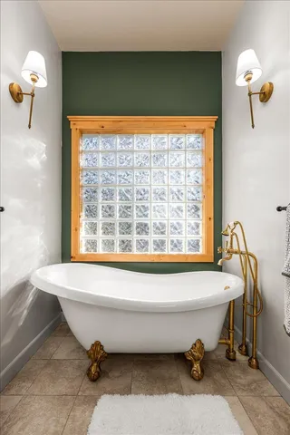 a spacious bathroom with a window bathtub and shower