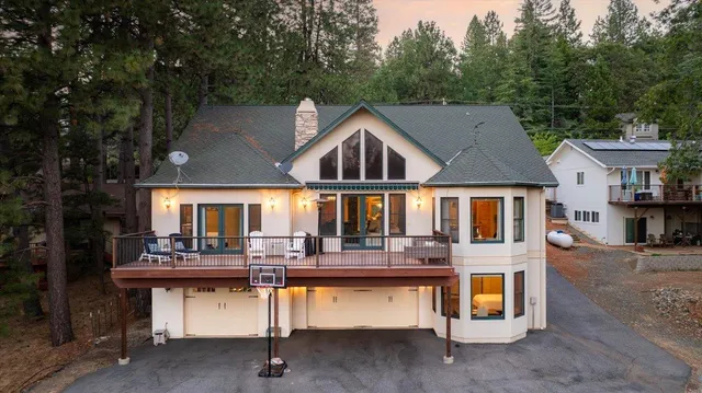 a front view of house with yard outdoor seating and covered with trees