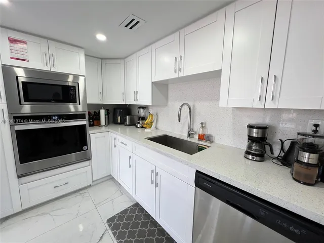a kitchen with a sink a stove and a refrigerator