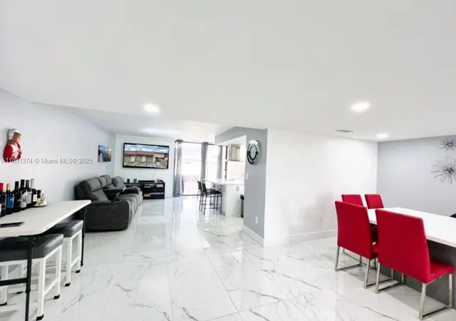 a kitchen with stainless steel appliances a table chairs and refrigerator