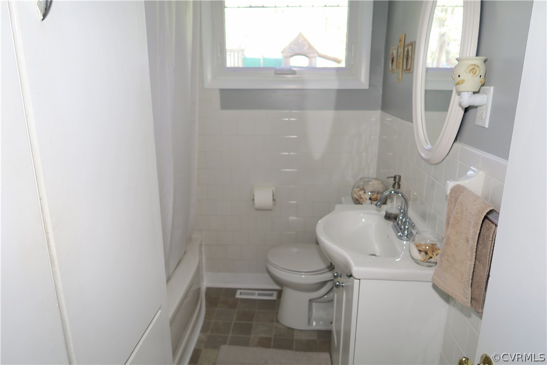 14400 Rivermont Road Chester, VA 23836 - Photo 10 of 15 a white toilet sitting next to a bathroom sink and a window
