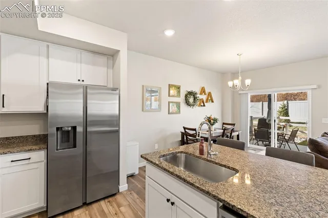 a kitchen with granite countertop a sink and refrigerator