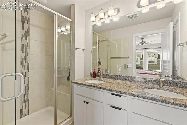 a bathroom with a granite countertop sink a mirror and a shower