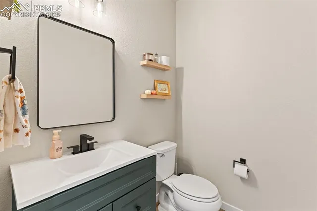a bathroom with a sink vanity mirror and toilet