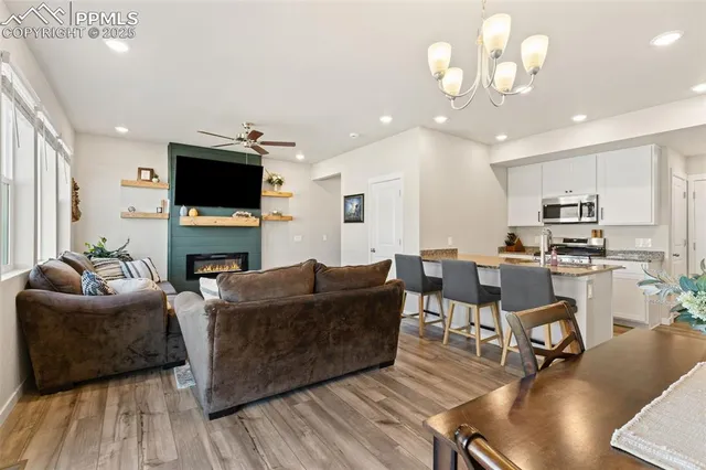 a living room with furniture a flat screen tv and kitchen view