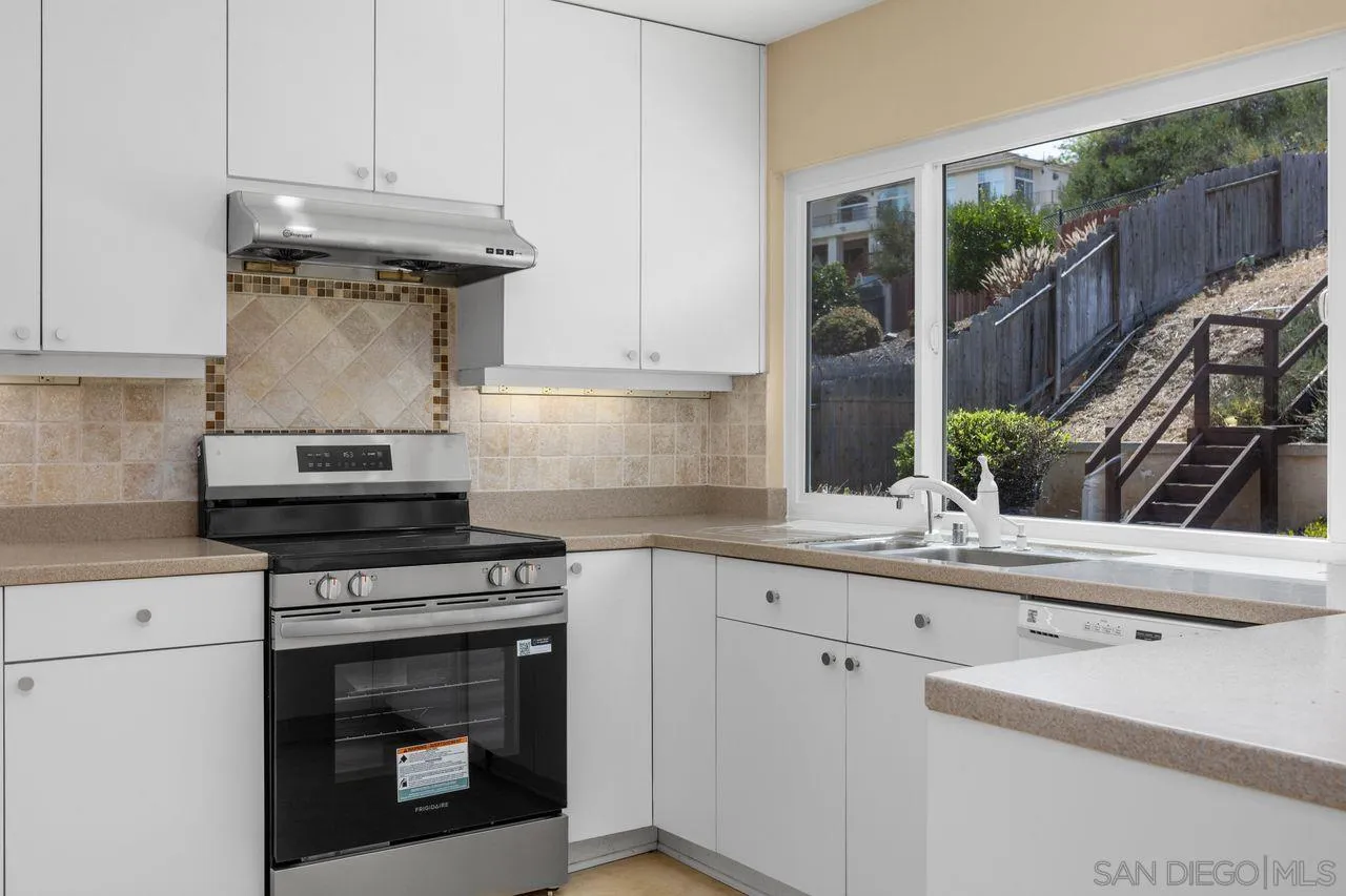 17054 Matinal Road San Diego, CA 92127 - Photo 17 of 50 a kitchen with granite countertop a stove fireplace and cabinets
