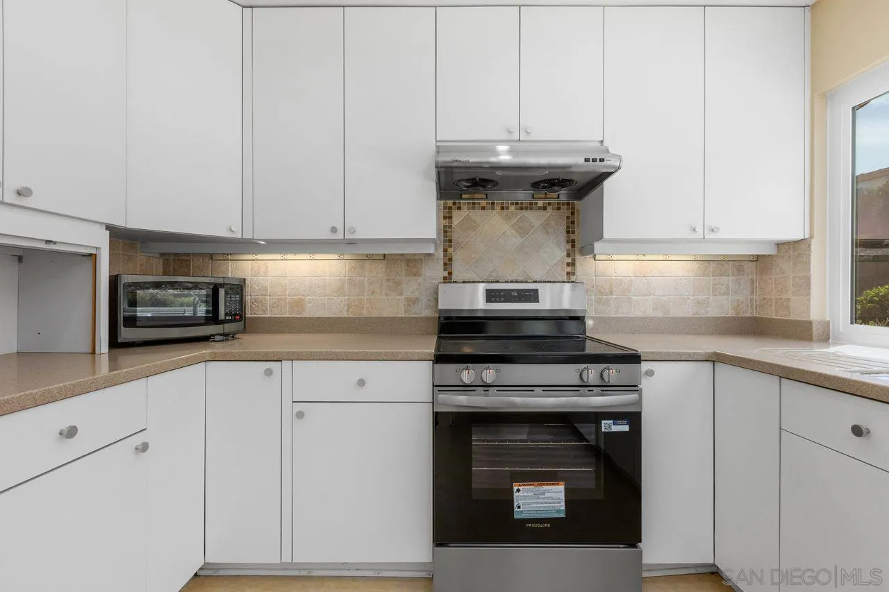 17054 Matinal Road San Diego, CA 92127 - Photo 19 of 50 a kitchen with granite countertop white cabinets and stainless steel appliances