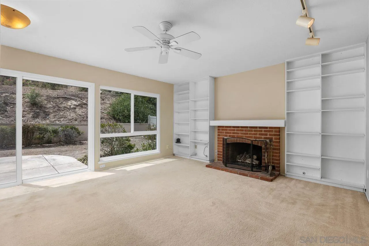 17054 Matinal Road San Diego, CA 92127 - Photo 8 of 50 a view of an empty room with a fireplace and a window