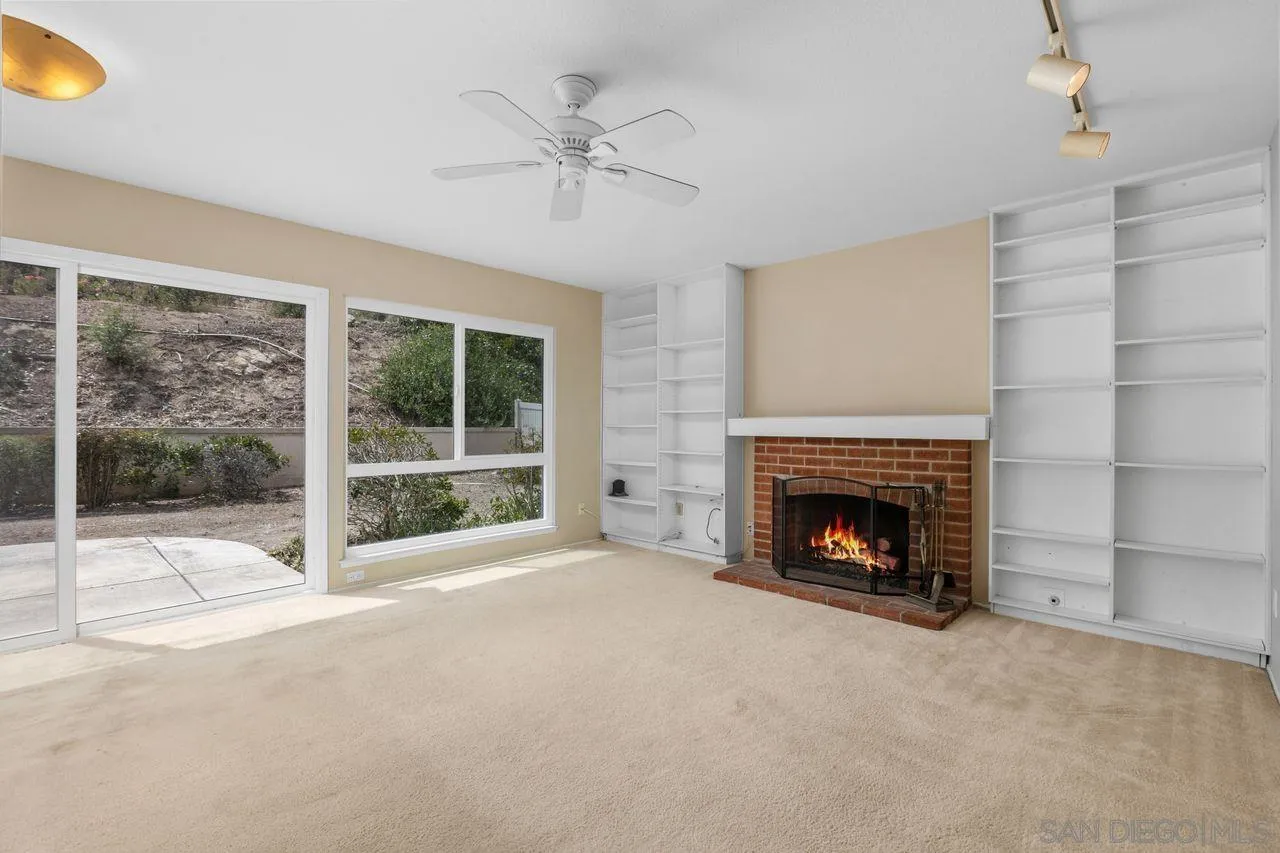 17054 Matinal Road San Diego, CA 92127 - Photo 9 of 50 a view of an empty room with a fireplace and a window
