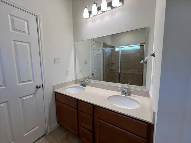 a bathroom with a sink double vanity granite and a mirror
