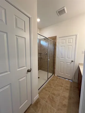 a bathroom with a shower and a glass door