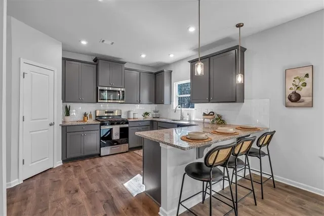 a kitchen with a stove a sink a dining table and chairs