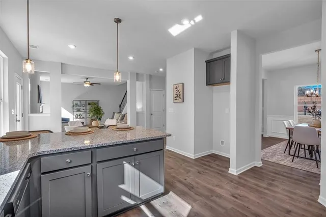 a kitchen with stainless steel appliances granite countertop wooden floor and refrigerator