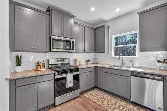 a kitchen with stainless steel appliances granite countertop a stove a sink and a microwave