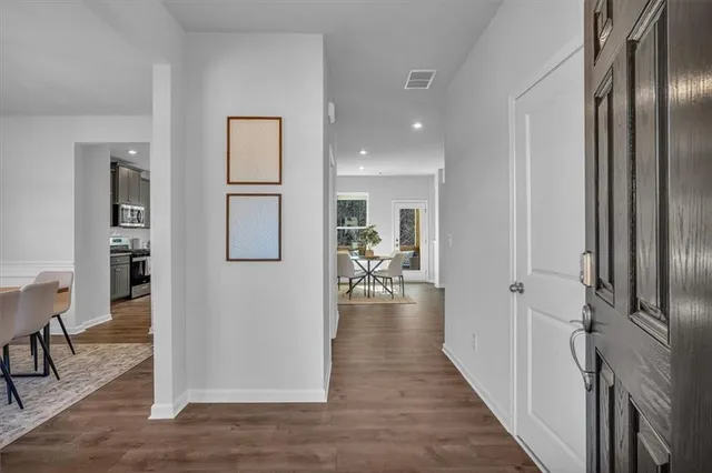 a view of a hallway with wooden floor windows and livingroom