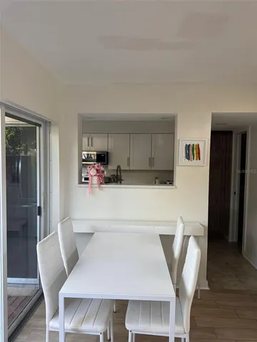 a living room with furniture and a dining table with wooden floor