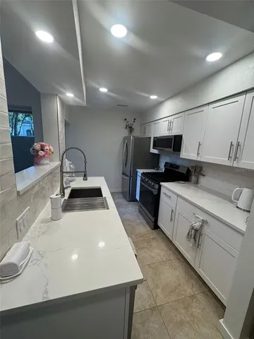 a kitchen with stainless steel appliances a sink dishwasher stove refrigerator and microwave