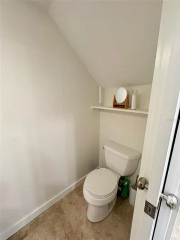a white toilet sitting next to a wooden floor